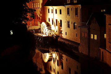 Night view on reflex in water of house near river