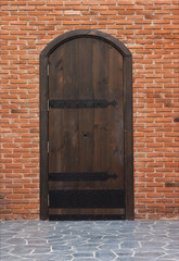 Old wooden gates and walls of red brick.