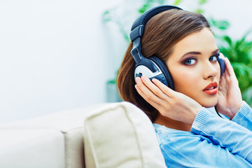 Beautiful girl face portrait with listening music in headphones