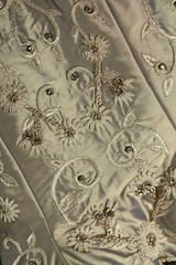 Background close up of vintage wedding dress fabric and beading