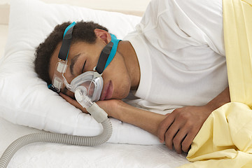 young  man  sleeping with apnea and CPAP machine