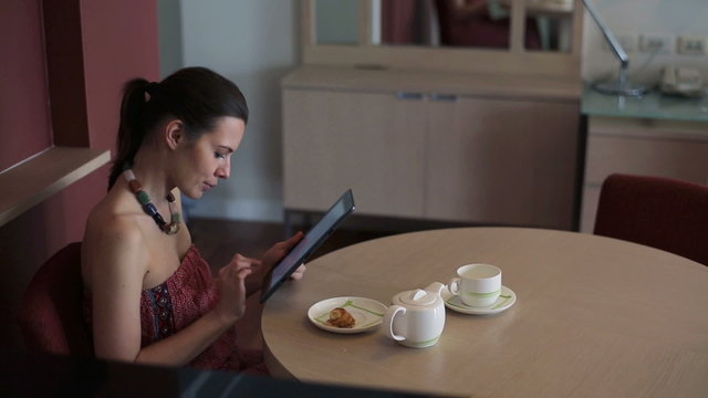 Young woman with tablet computer sit by the table at home