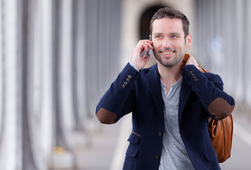 Young attractive man using smartphone in Paris