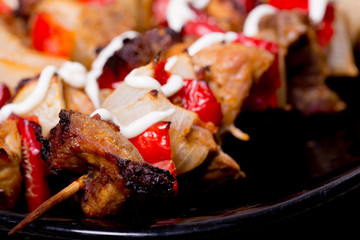 Grilled shashlik on the black plate,