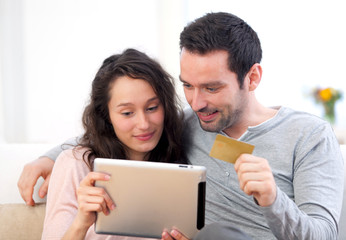 Young happy couple shopping on a tablet