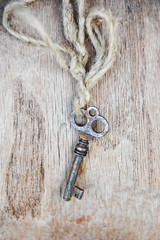 Vintage rusty key on old wooden background