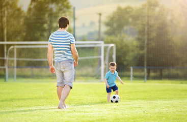 Obraz premium Father and son playing football