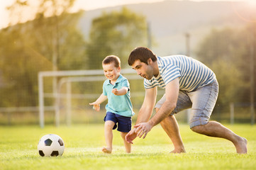 Father and son playing football