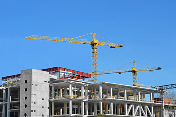 Crane and building construction site against blue sky