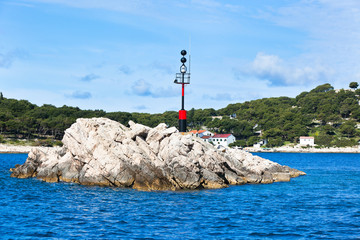 Nautical danger sign on a rock in the sea
