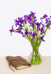 Beautiful bouquet of iris flower in vase on tablel with old vint