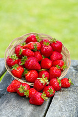 basket with strawberries on a garden wooden table