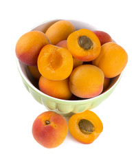 fresh apricots in a bowl over white