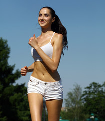 Young woman running in summer park