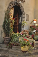 Fototapeta na wymiar building with a wooden gate and on the steps of vases with flowe