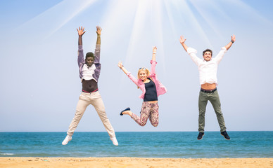 Multiracial friends jumping at the beach