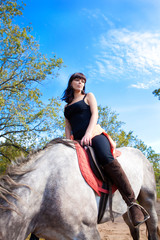 young beautiful girl on horse walk in the summer on background
