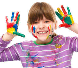 Portrait of a cute girl playing with paints