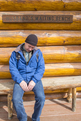 Husband Waiting for Wife on a Bench Outside of a Store