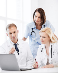 doctors looking at laptop on meeting