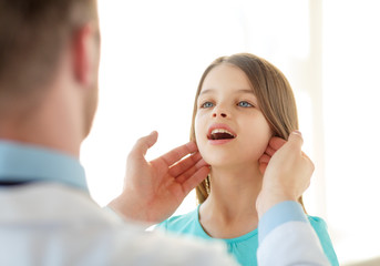 male doctor checks little girl lymph nodes