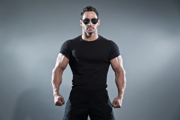 Combat muscled action hero man wearing black t-shirt with pants