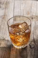 Vaso de licor con hielos whiskey cognac ron en la mesa del bar