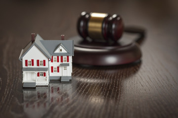 Gavel and Small Model House on Table