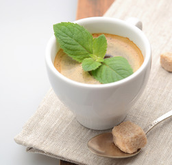 coffee cup with mint on a napkin with brown sugar