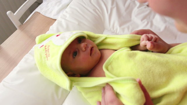 cute infant wrapped in a towel after bath