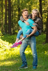 Fototapeta premium Happy teenage couple having fun outdoors on sunny day
