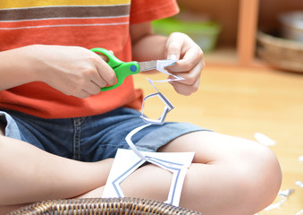 Little hand's boy cutting paper montessori materials