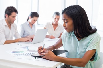 Fototapeta premium Casual businesswoman taking notes during meeting
