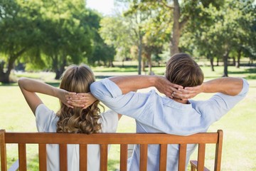 Couple relaxing on park bench together