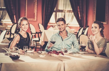 Young friends with glasses of wine in a restaurant