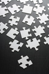 Blank white jigsaw pieces scattered across a blackboard