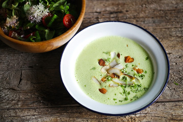 Green pea creamy soup with coconut and nuts, salad