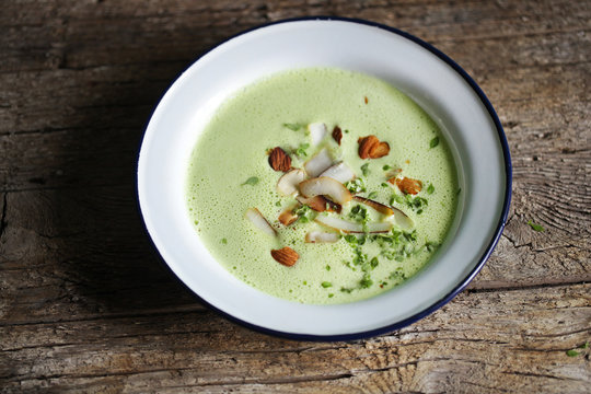 Pea cream soup with coconut, almonds and herbs