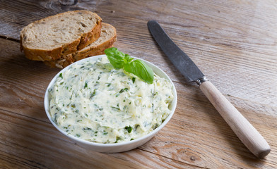 Kräuterbutter in einer Schale auf Holz