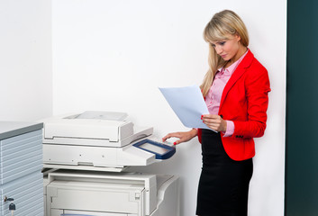 business woman with documents standing next to printer