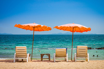 Beach umbrella and sunbath seats and side table