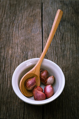 Red onion in ceramic bowl with wooden spoon