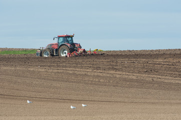 Obraz premium Tractor ploughing agricultural land