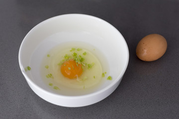Raw egg in a white bowl