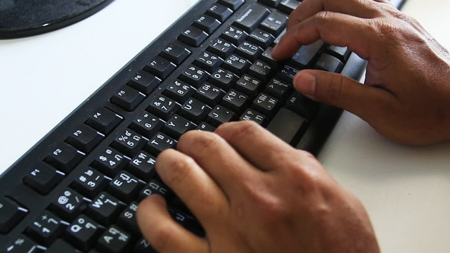 Man to typing computer keyboard