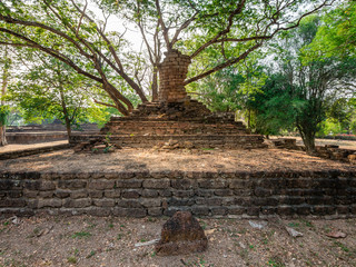 Broken ancient Buddha under a tree at Kamphaengphet Historical P