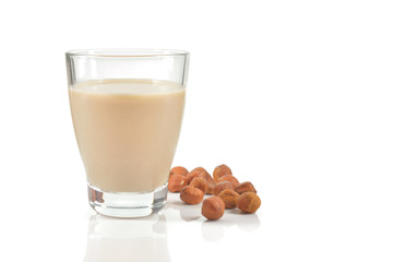 Glass of hazelnut milk or drink on white.