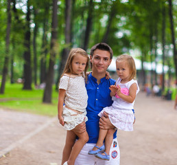 Young Father and his adorable daughters having fun outdoors