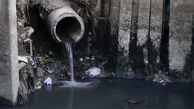 Dirty drain polluting a river