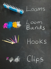 loom bands and looming tools on a blackboard